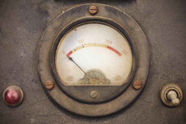 Un indicatore analogico con lancetta e una zona rossa di limite
