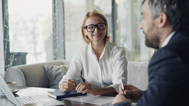 Un colloquio a un tavolo, con appunti e un portatile
