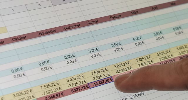 Un dito indica una cifra in un foglio di calcolo dei flussi mensili